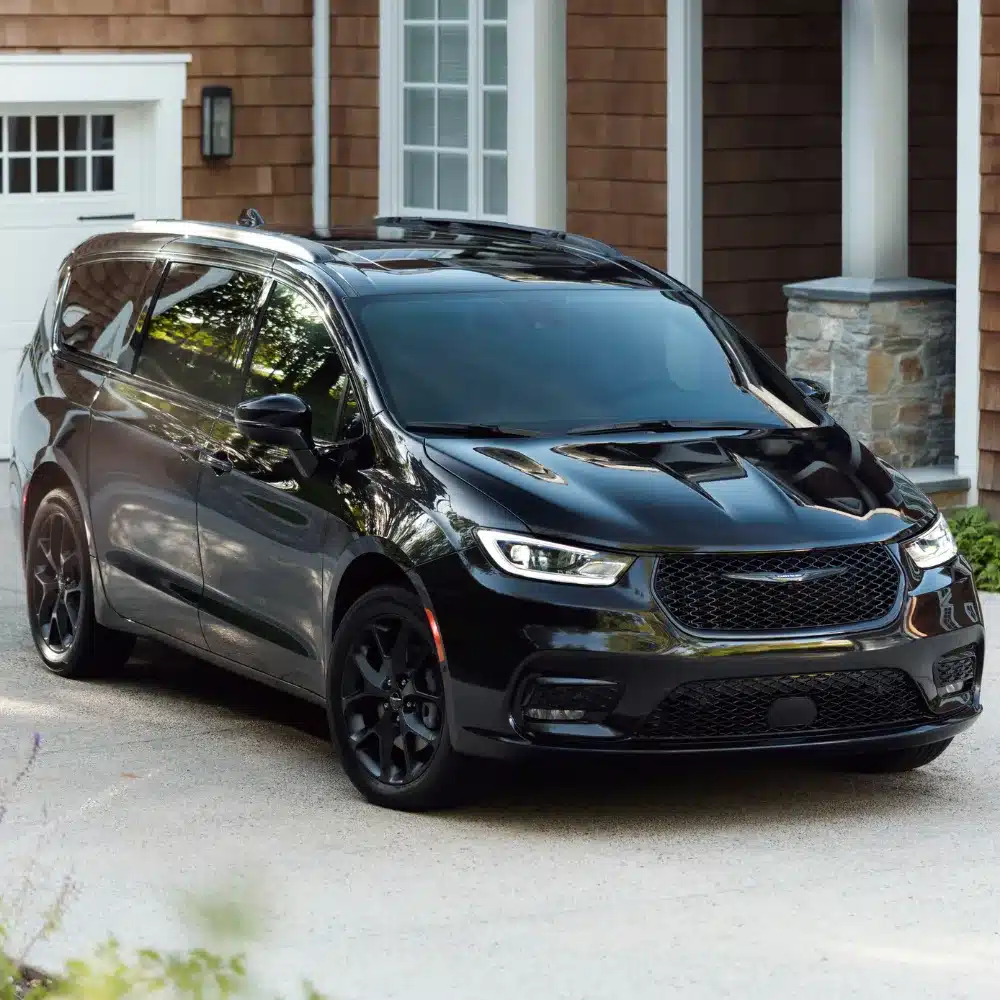 A shiny new Chrysler Pacifica parked prominently outside a modern Gengras CDJR dealership in Connecticut.