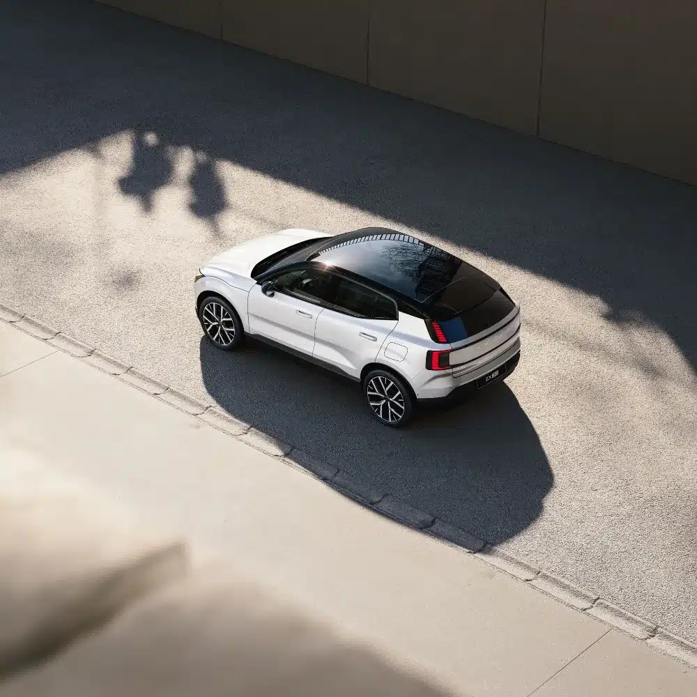 drive-home-a-new-volvo-with-financing-options-designed-around-your-budget A family excitedly looks at a new Volvo SUV in a showroom, discussing financing options.