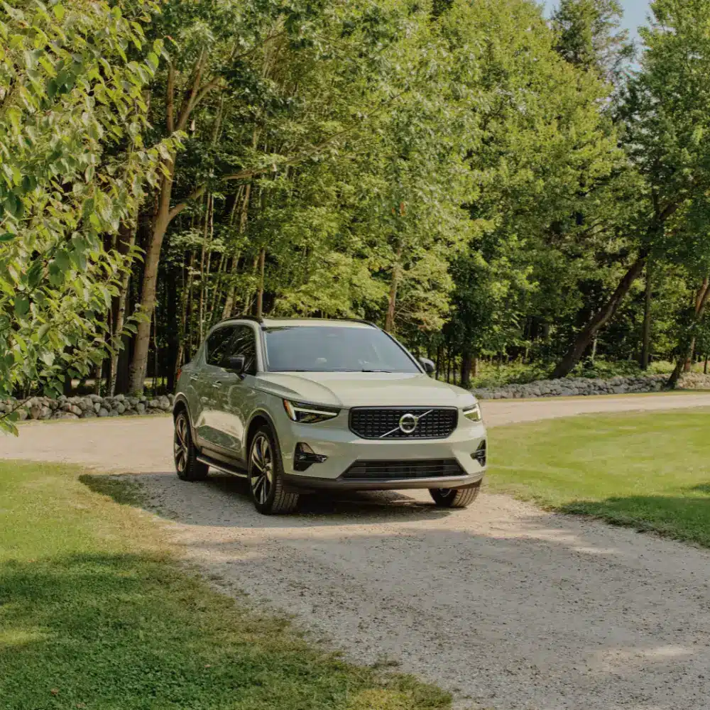 A sleek white Volvo XC40 Recharge parked elegantly on a modern city street.
