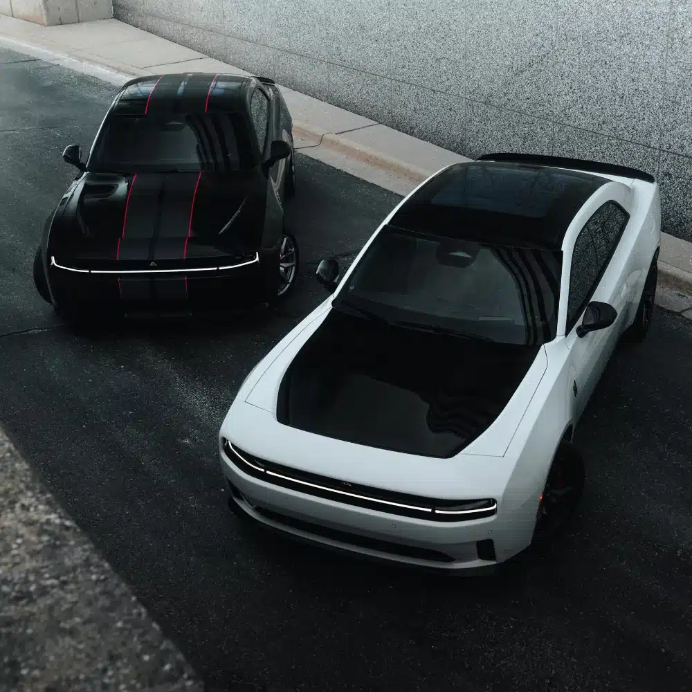 A customer happily discussing vehicle options with a salesperson at a modern Dodge dealership.